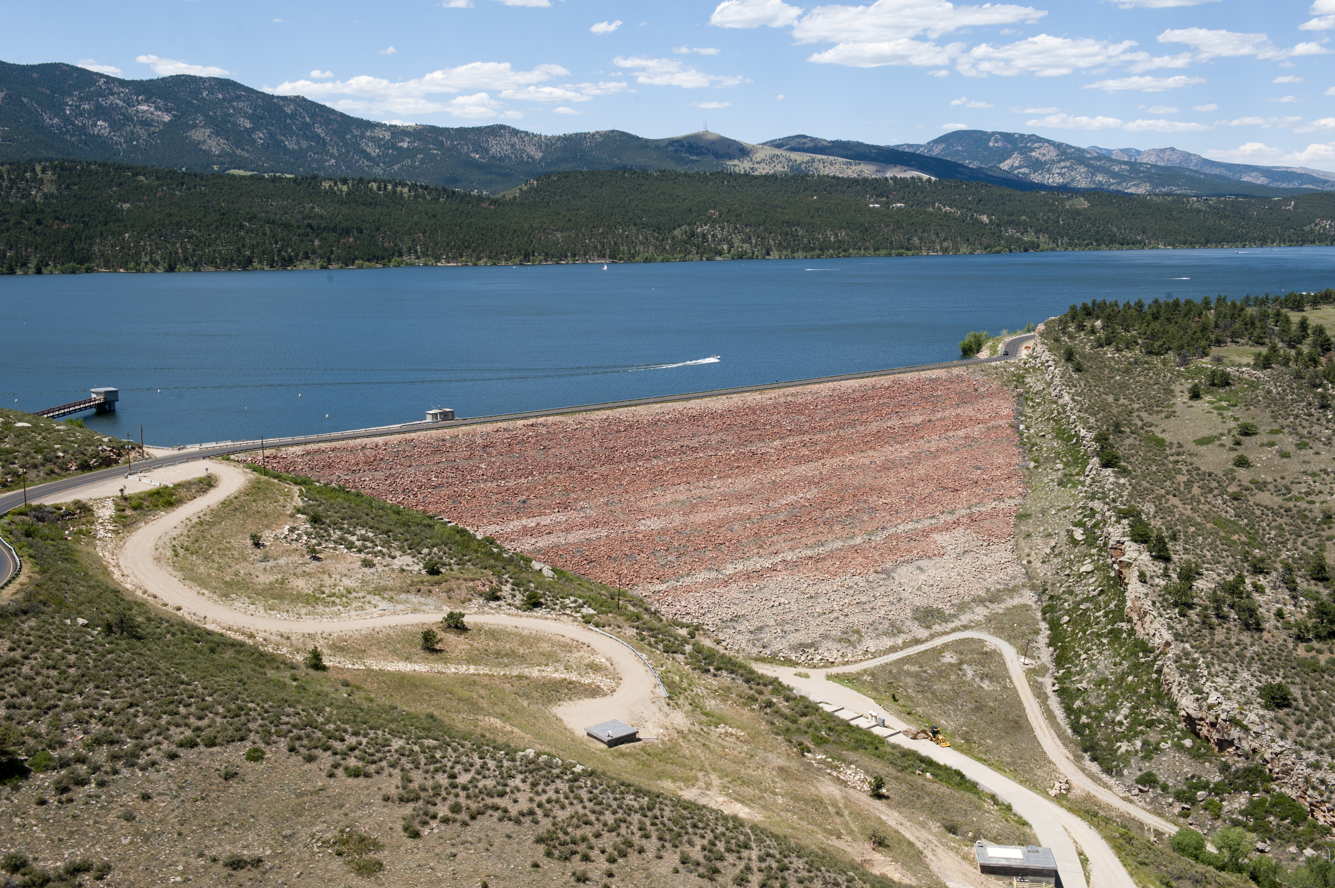 Horsetooth Reservoir and Dixon Dam in summer with Rocky Mountains in the far background.