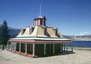 Dexter's house after relocation and restoration. The Mount Elbert Powerplant whose construction precipitated the relocation is seen across the lake at the right of the porch roof.
