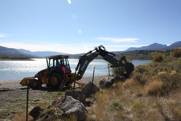 Workers move boulders into place at Green Mountain Reservoir to prevent unauthorized boat launches.