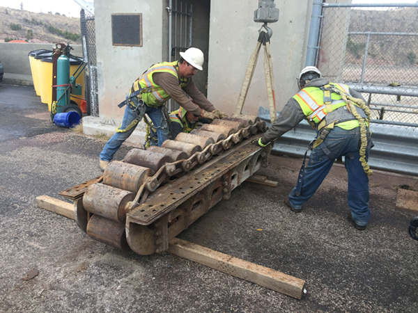 (Left) Workers inspecting roller train after removal.
