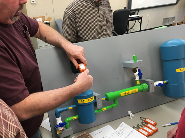 Trent Bennett, Mechanic Foreman 1, applies a lock to the compressor power switch on the model.