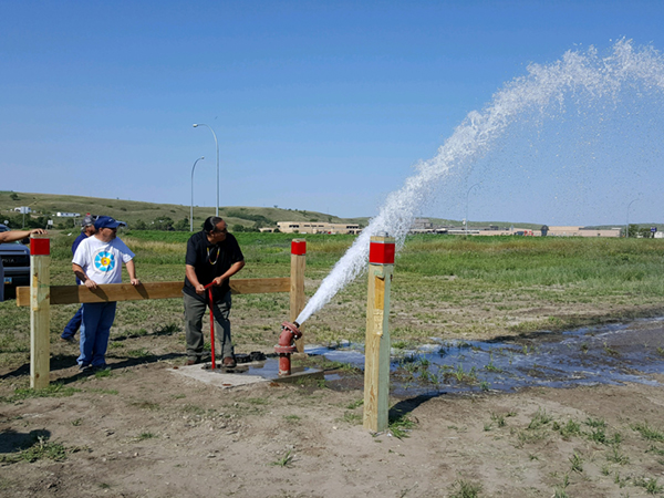 Turning the valve is Standing Rock Sioux Tribe Councilman Charles Walker. He is the son of the late Ralph Walker who served for many years as the Director of the Standing Rock Rural Water System and was an avid advocate for getting water to all the people of Standing Rock.