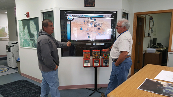 Tom Ridley (left) and Tom Thompson (right) discuss the computer program that monitors the newly operational Standing Rock Rural Water Supply System. This interactive computer program provides real-time information on each of the System components.