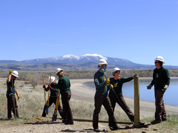 A Montana Conservation Corps crew replaces deteriorated fence to block unauthorized OHV access.