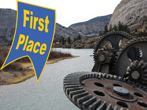 First place winner. Bob Marshall Wilderness beyond the river outlet works gate hoist gears of the Sun River Diversion Dam by Joe Rohde.