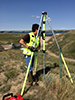 Ron Robertson adjusting the tripod to begin a topographical survey at Fresno Dam in Havre, Mont. Photo by Anellise Deters.