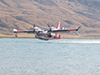 A Bombardier 415 Super Scooper Aircraft lifts off from Buffalo Bill Reservoir after loading water to fight the Whit Creek Fire. Photo by Mark Skoric.