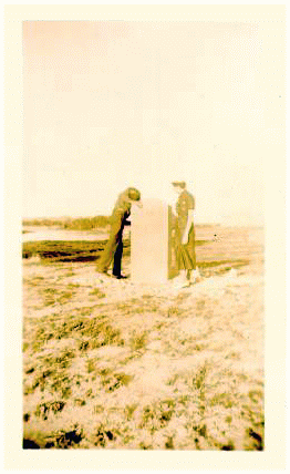 Man and woman examinig a Poney Express Station marker. Sepia tone photo.
