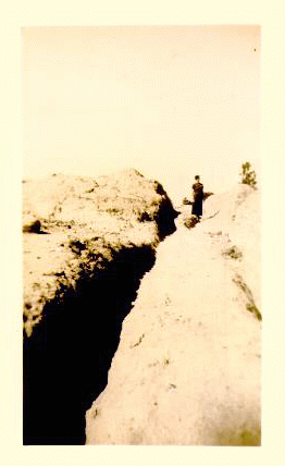 Woman standing in the nearly 4 feet deep ruts left on Covered  Wagon Hill. Sepia tone photo.