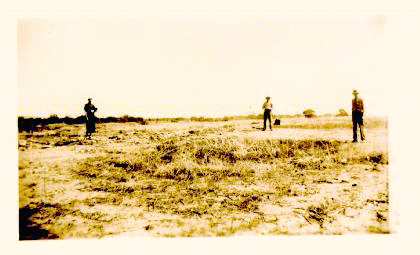 Two men and a woman standing in an empty field which use to be the site of Old Fort Bernard. Sepia tone photo