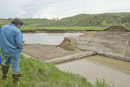 An irrigation district staffer looks over the failed Pryor Creek crossing structure for the Huntley Project canal.