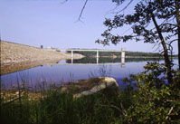 An image of McGee Creek Reservoir in Oklahoma showing a portion of the dam, reservoir and the intake for a municipal water pipeline.
