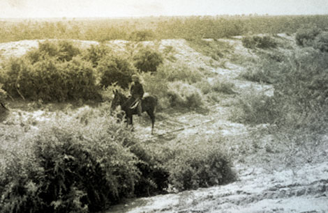 The horseman is riding in a prehistoric Hohokam irrigation canal near Mesa, 1907. (Reclamation photograph)