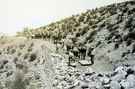 Apache teamsters placing fill on the new Tonto Highline Road.  Note the dry-laid masonry retaining wall. (Reclamation photograph)