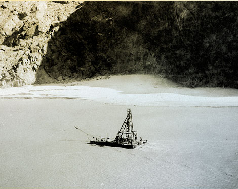 A 1922 photograph shows a barge with a drill testing the river bed to assess its composition and structure. (Reclamation photograph)
