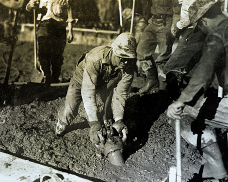 When concrete is poured, it is important to eliminate air pockets.  Here workers use a vibrator to settle the concrete and remove air pockets.  (Reclamation photograph)