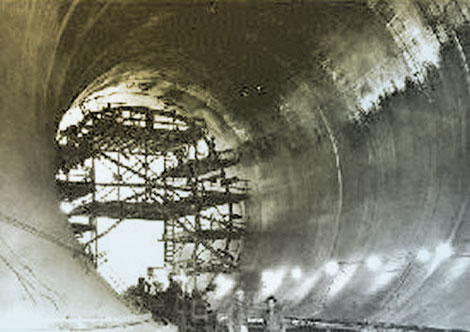 Four 50 ft. diameter diversion tunnels, two on each side of the canyon, were drilled through rock to carry water around the construction site.  Upon completion, each tunnel was lined with 3 feet of concrete. (Reclamation photograph)