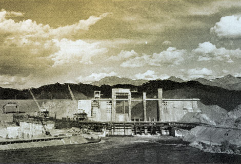 The river is rising – but no cause for alarm. A lake 67 miles long is being created behind Davis Dam, shown with the stop logs in place, raising the water at the dam to a depth of 70 feet. The Arizona end of the dam is at the left.