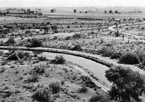 The Salt River Project's Cross Cut Canal in southwestern Scottsdale, Arizona in 1947. The landscape is primarily open desert, undeveloped, with irrigated farmland visible in the distance. Reclamation ERA photo.