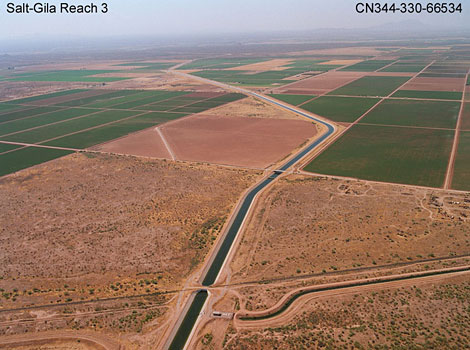 Central Arizona Project canal, showing farmlands made possible by the delivery of irrigation water and a turn-out structure into a local canal.