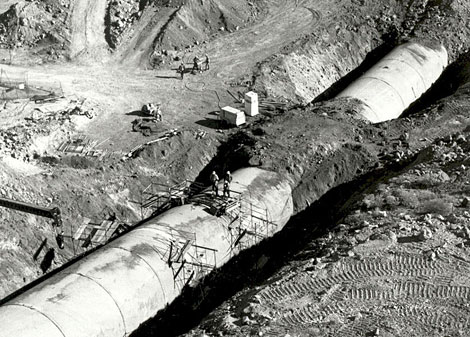 A section of the Agua Fria siphon being buried. Note the workmen standing on top of the pipe to get an idea of the pipe size.