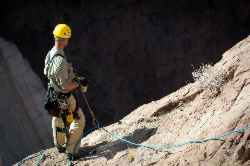 Scott Foster checks on the position of his fellow climbers before climbing down the cliff face.