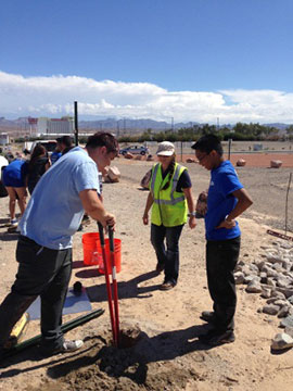 Cheri Woodward, center, of RMO, supervises while students install the Desert Trail Trailhead Parking Sign.