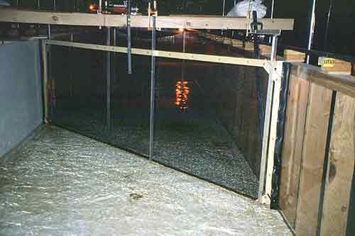 Mechanical crowder being tested in a research flume in the Hydraulics Research Laboratory at the Bureau of Reclamation's Technical Service Center, Denver, Colorado.