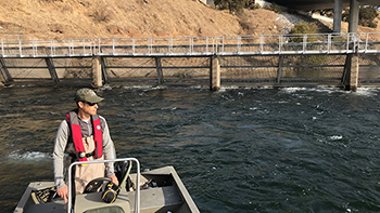 Boat Operator observes his surroundings from the helm of a bout that is underway.