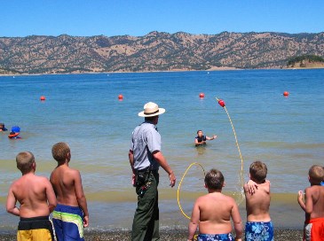 photograph of children in the water getting life saving tips from a ranger; click for larger photo