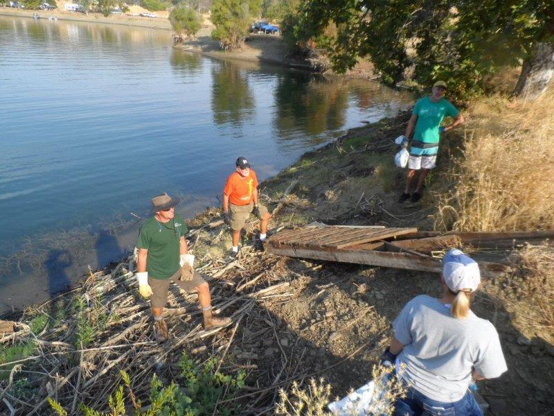 Volunteer cleaning up trash along the coast of Lake Berryessa