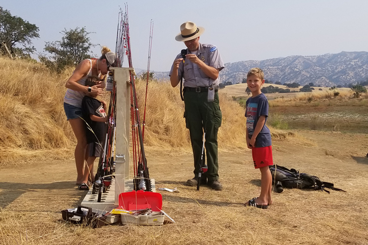 Park ranger helps to tie a line with guests at the free fishing event.