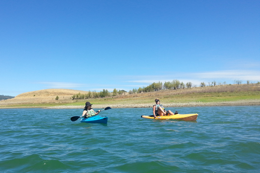 Two kayakers chatting while on the water.