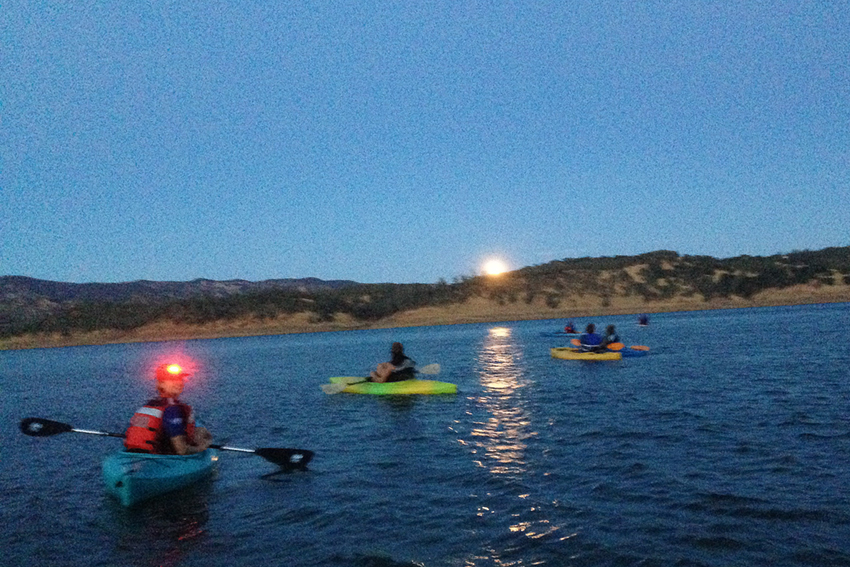 Evening kayak event with headlamps on.