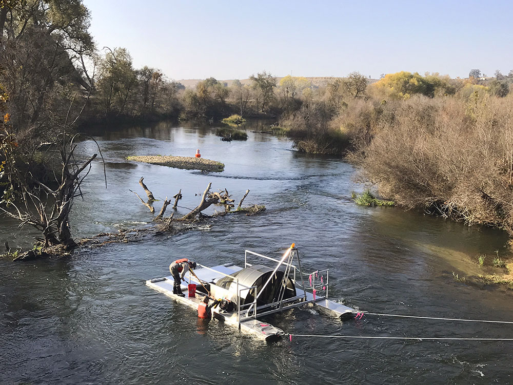 San Joaquin River Restoration Program staff check a rotary screw trap for newly emerged spring-run Chinook salmon - Photo by Josh Newcom