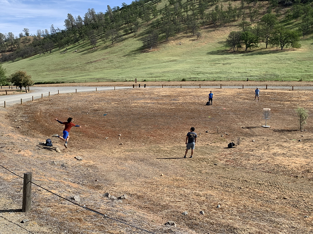people playing on skip disc golf course area
