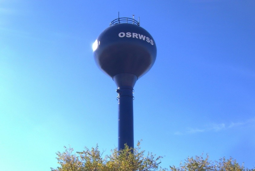 Photo of blue water tower with sky in background