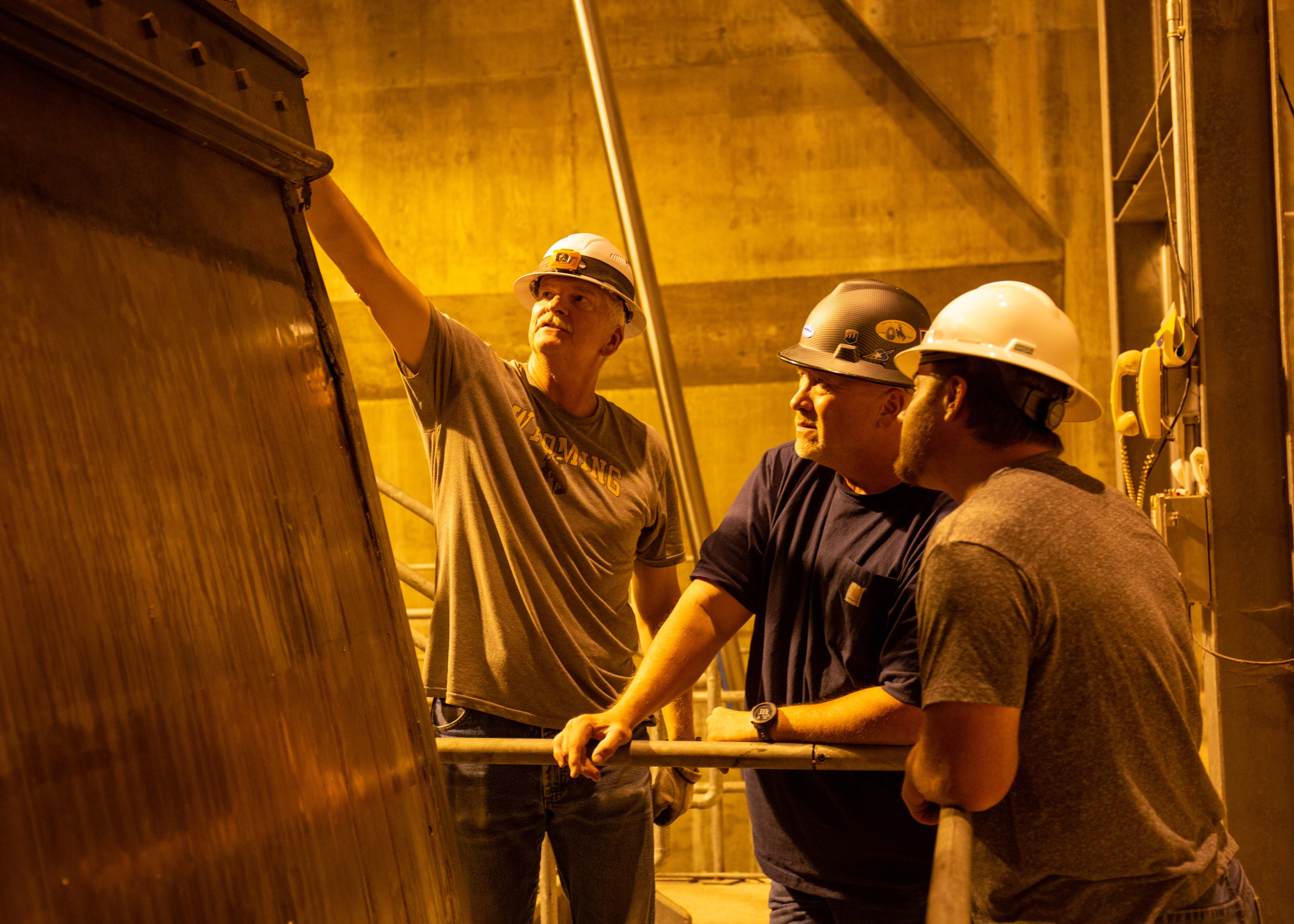 Reclamation employees inspect a spillway gate at Buffalo Bill Dam.