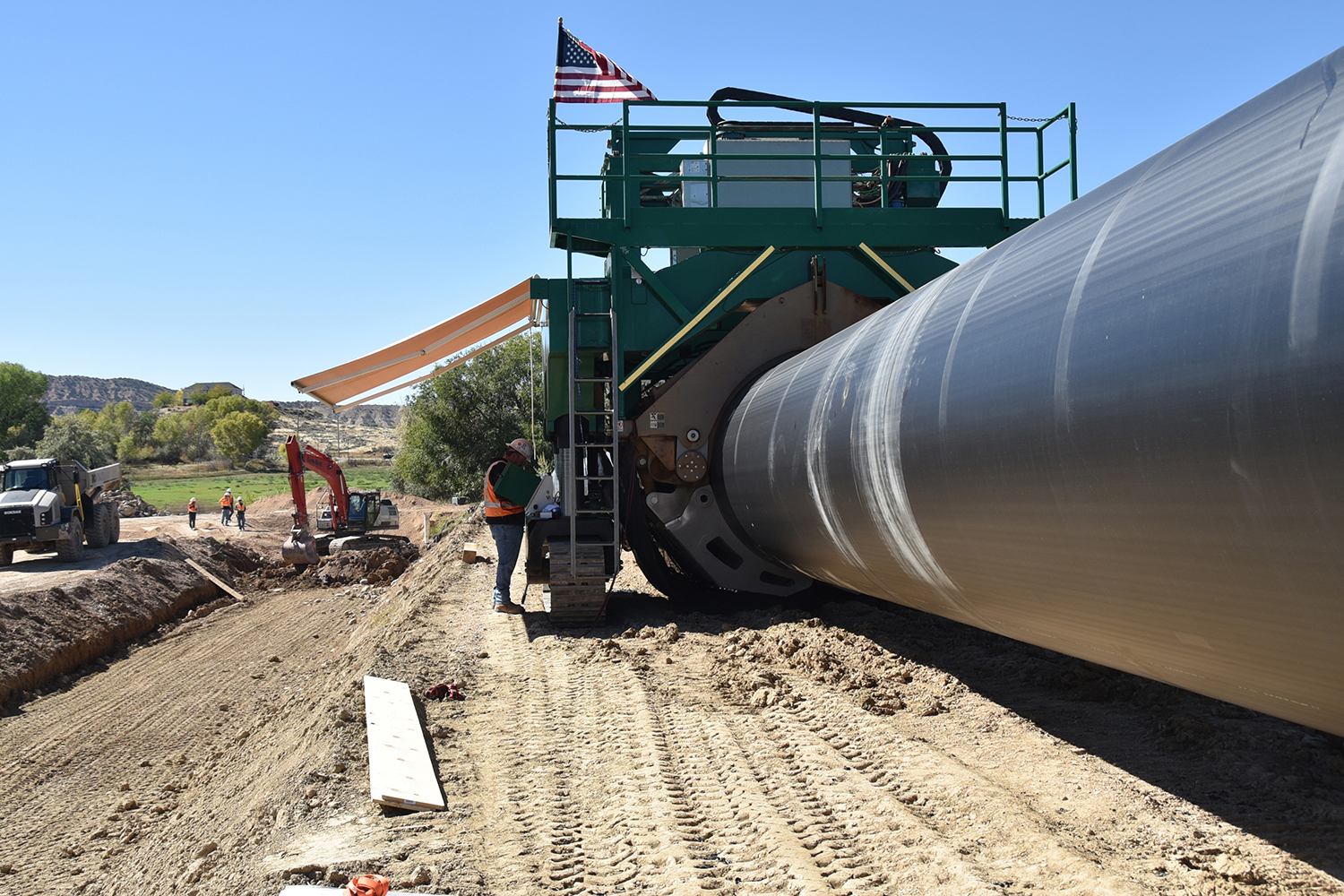Workers at the Steinaker Service Canal Pipeline Project site operate a Talon fusing machine to fuse together two sections of 84-inch-diameter HDPE pipe. 