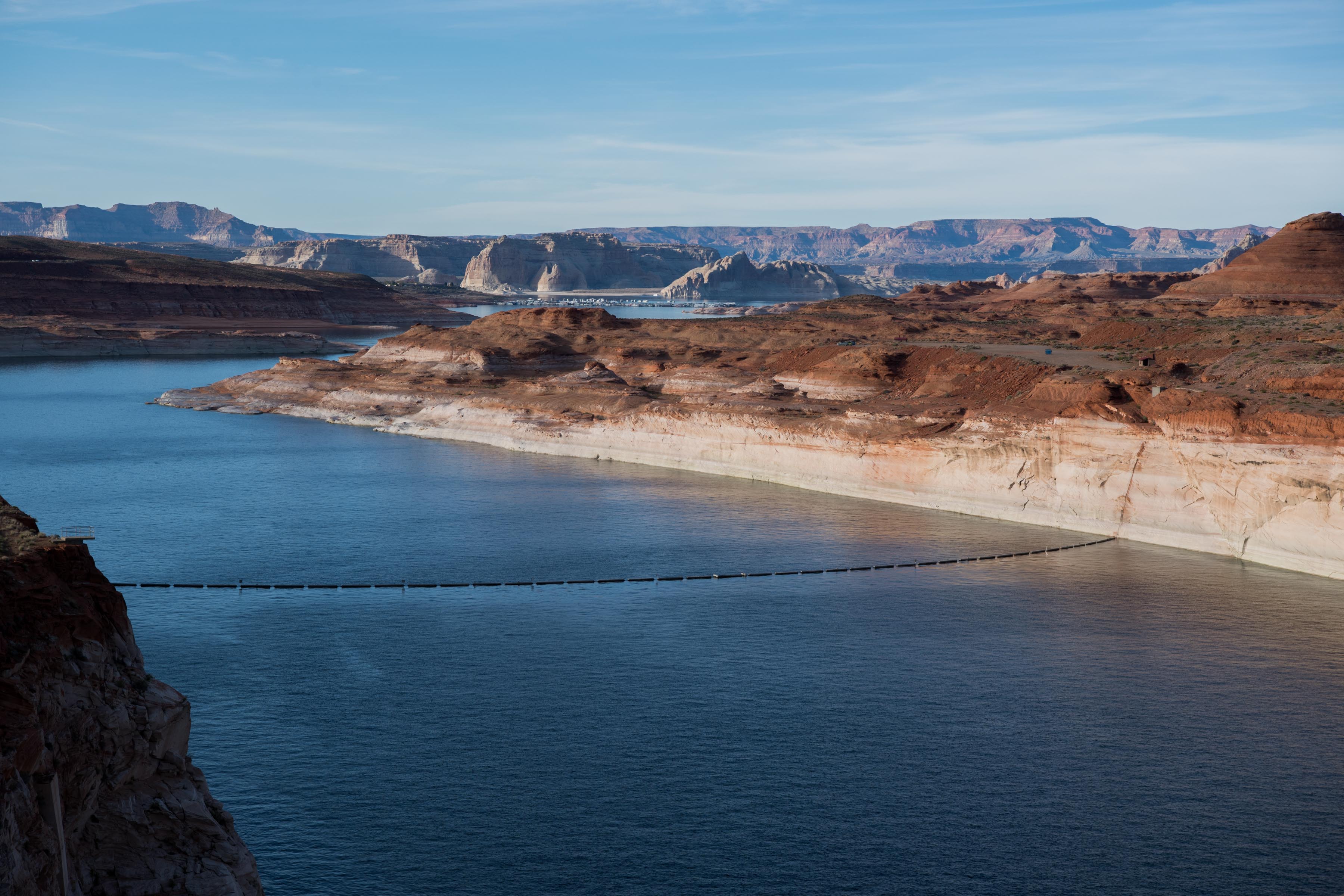 Photo of Lake Powell looking north from Glen Canyon Dam with mountains in the background as the sunsets.