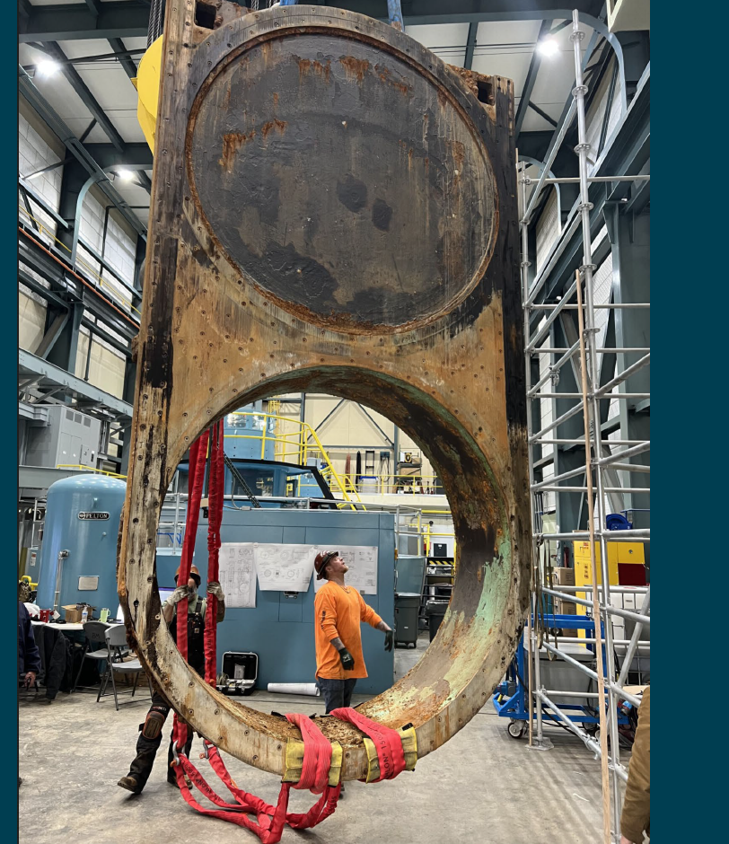Crews help guide the removed ring follower gate to a flatbed truck so it can be transported to California for refurbishment.