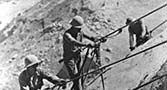 Drilling blasting holes in rock face for Grand Coulee Dam.
