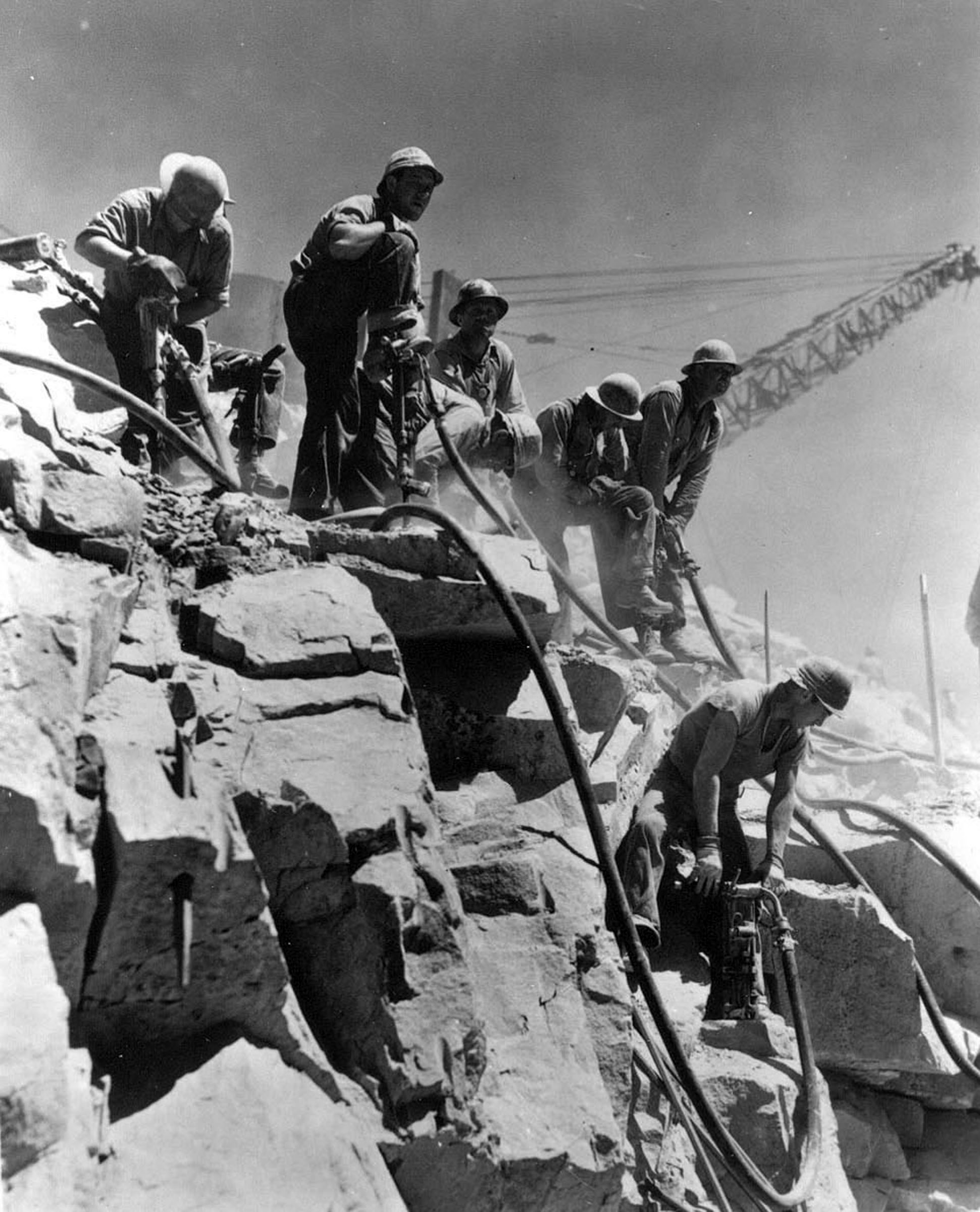 Photo taken Circa 1938. Drilling blasting holes in rock face for Grand Coulee Dam.