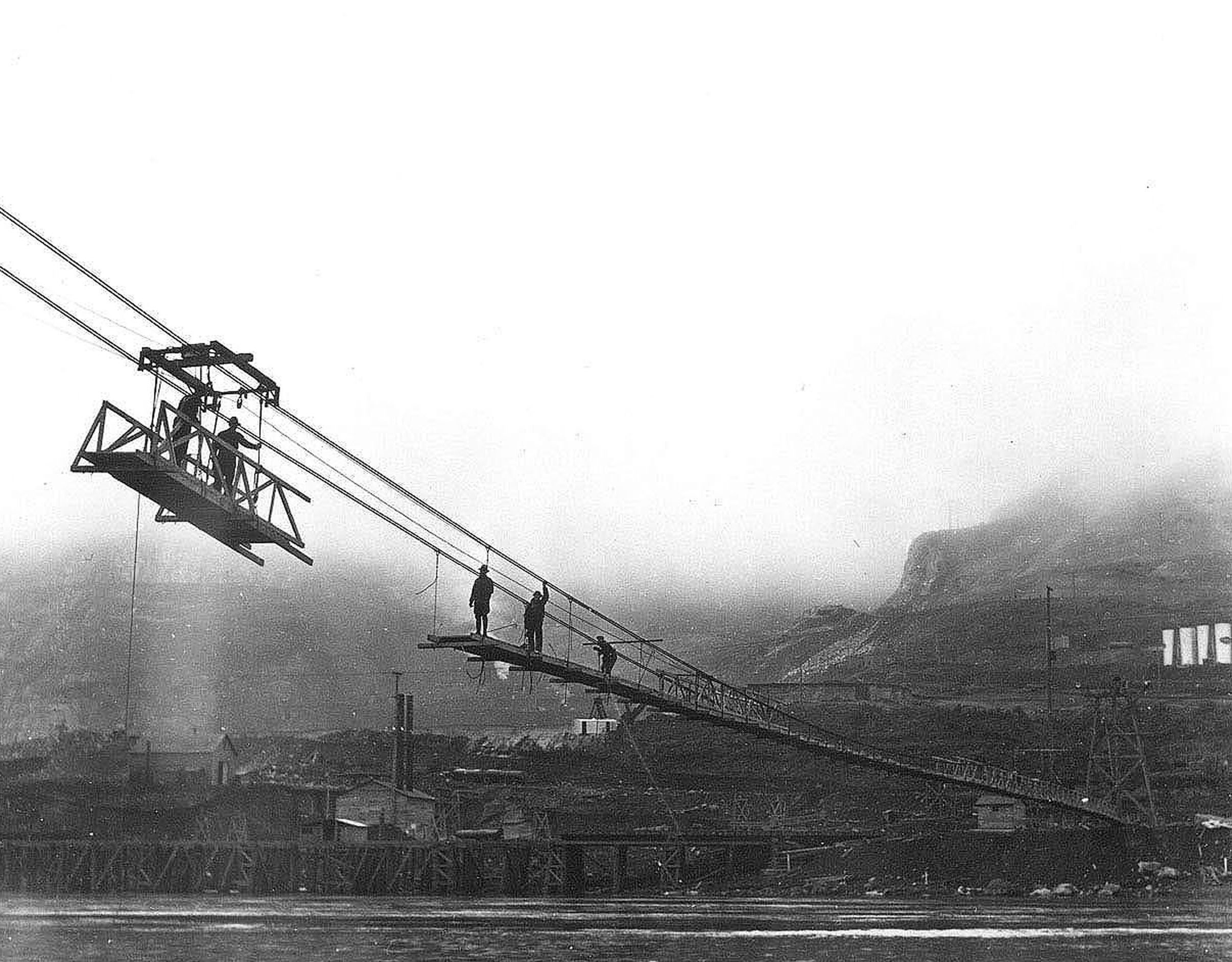 Photo taken February 1935. Contractors catwalk being built so workers could cross the Columbia River at the Grand Coulee damsite.