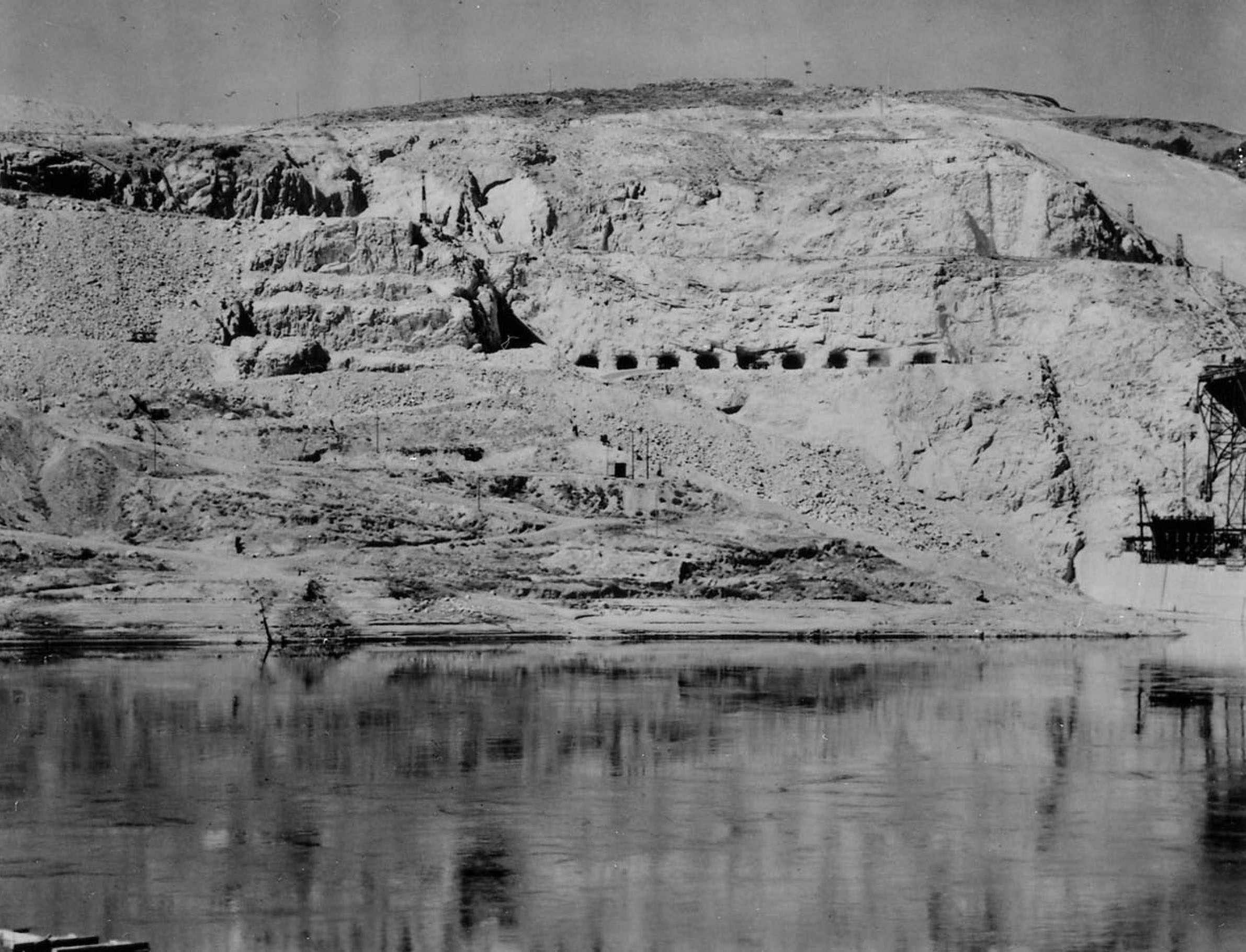 Photo taken August 24, 1938. 9 of the 12 discharge tunnels for the pumping plant seen here on the west side of Grand Coulee Dam.