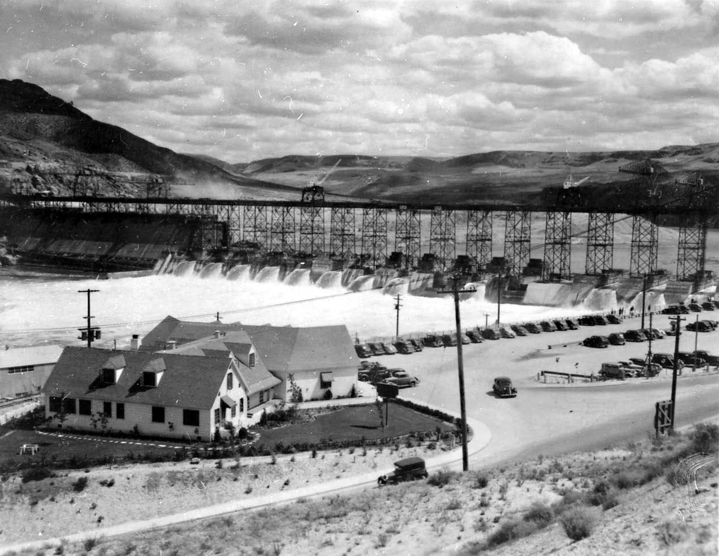 Photo taken July 4, 1939. The Green Hut restaurant in the foreground was built by C.D. Newland on leased land here at Grand Coulee Dam.