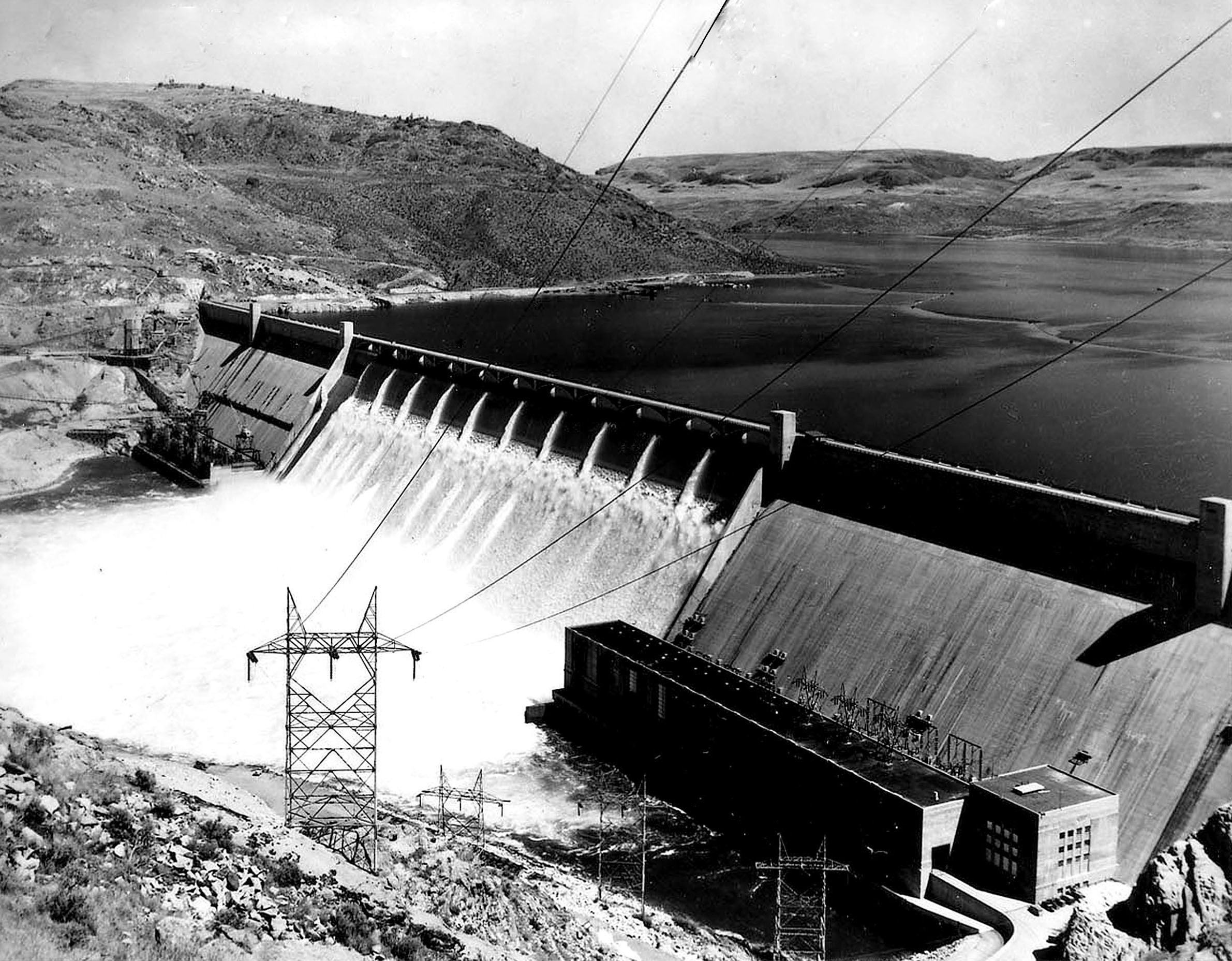 Circa 1942. View of the Grand Coulee Dam from the west side cliffs.