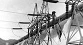 Installing transmission lines from the west powerhouse to the 230 KV switchyard at Grand Coulee Dam.