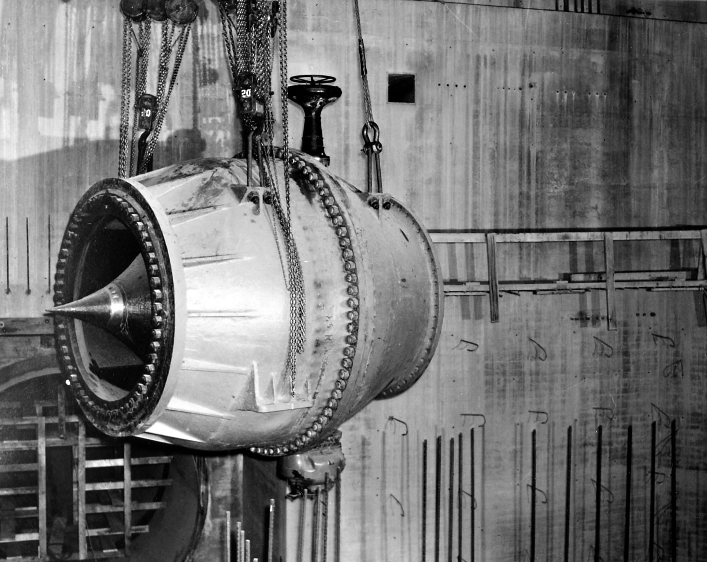 November 24, 1944. This needle valve being lowered into base of R-8 in the east powerhouse of Grand Coulee Dam.