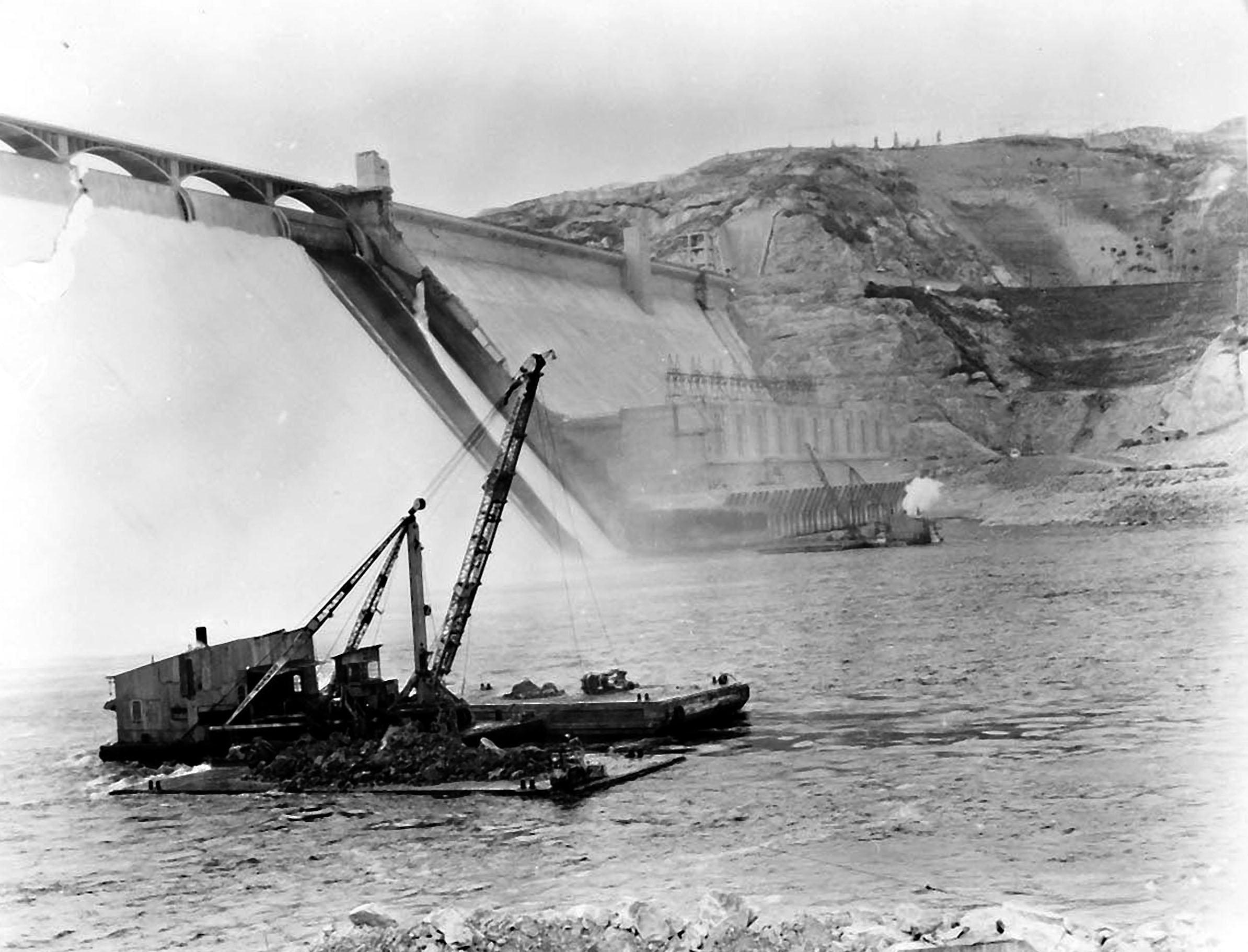 January 27, 1947. Excavating river bottom prior to setting up caison for spillway bucket repairs at Grand Coulee Dam.